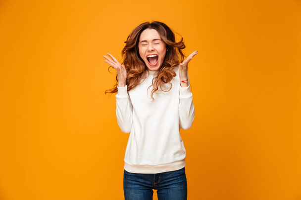 Confused brunette woman in sweater screaming with closed eyes - Photo, image
