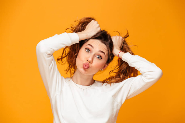 Funny brunette woman in sweater holding her hair - Foto, immagini