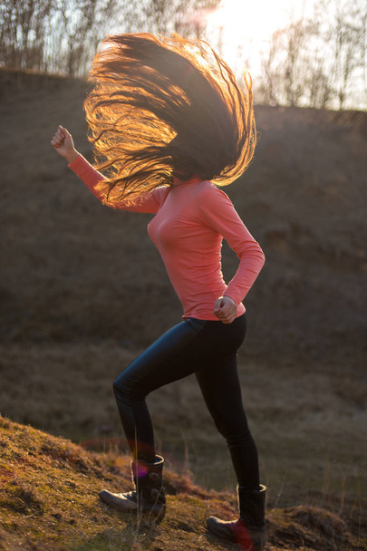 Girl with long hair in spring, Dancing girl in the mountains, heavy metal rock - Photo, Image