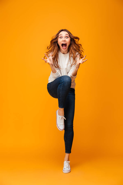 Full length image of Shocked screaming brunette woman in sweater - Фото, изображение