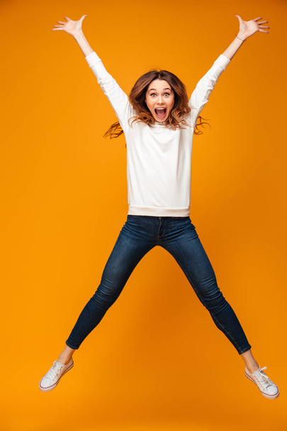 Full length image of Screaming brunette woman in sweater jumping - Fotó, kép