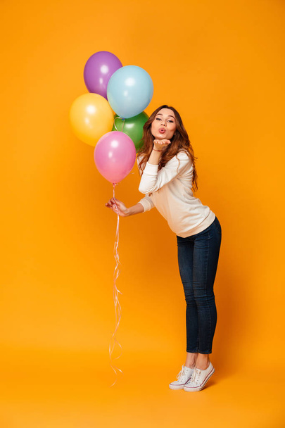 Excited young woman looking camera holding balloons blowing kisses. - Фото, зображення