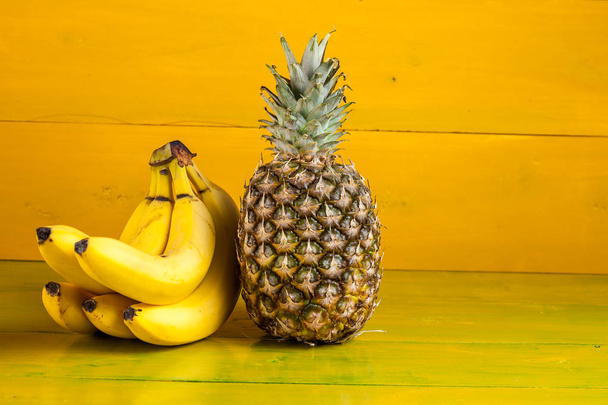Trooppiset hedelmät keltaisella puupohjalla, tuoreet elintarvikkeet
 - Valokuva, kuva