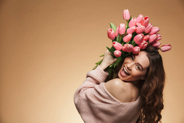 Excited screaming beautiful young woman holding tulips flowers - Fotó, kép