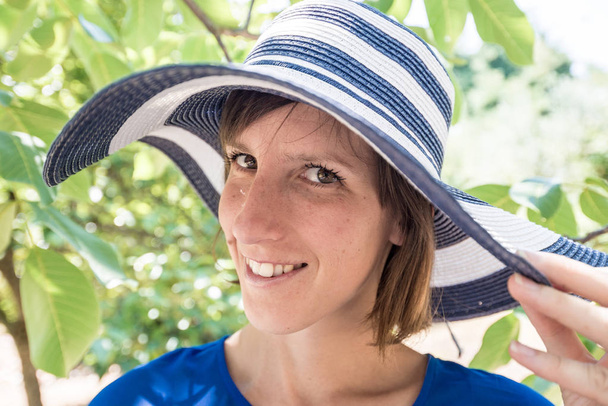 Mujer sonriente en un elegante sombrero de sol
 - Foto, Imagen