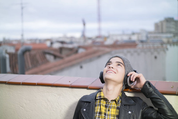 mladík s smartphone a sluchátka na ulici - Fotografie, Obrázek