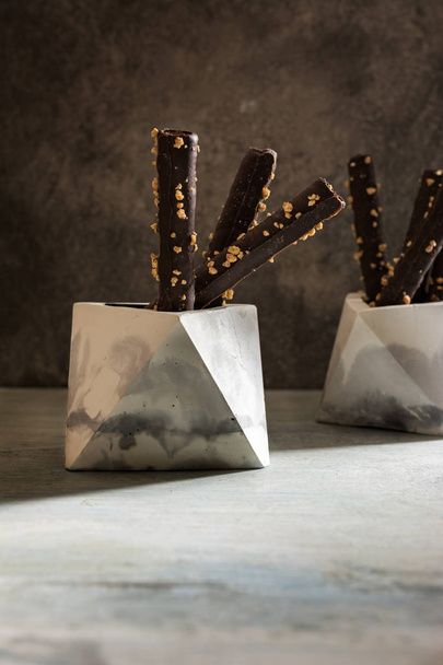 Waffelschokoladenrollen mit Mandeln, in geometrischer Schüssel - Foto, Bild