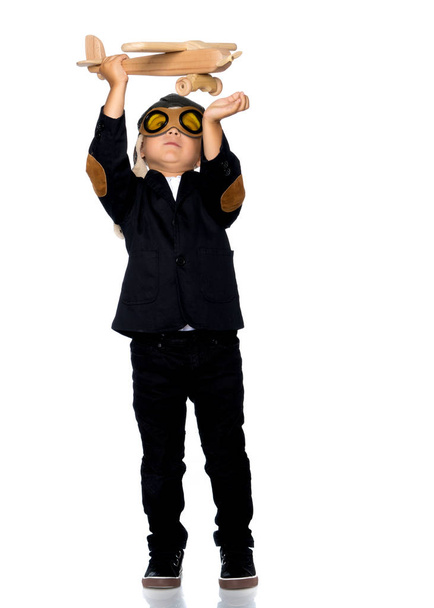 Маленький хлопчик грає з дерев'яним літаком
 - Фото, зображення