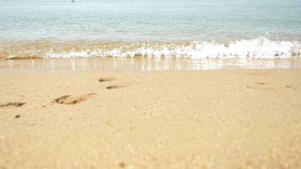 arena dorada, espuma de mar blanca y cielo azul con una playa y movimiento de olas marinas tropicales, hora de verano para el descanso y la recreación. 4k, cámara lenta
 - Imágenes, Vídeo