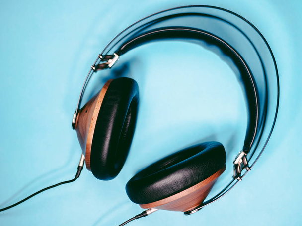 black wooden headphones audio for listen isolated on blue background - 写真・画像