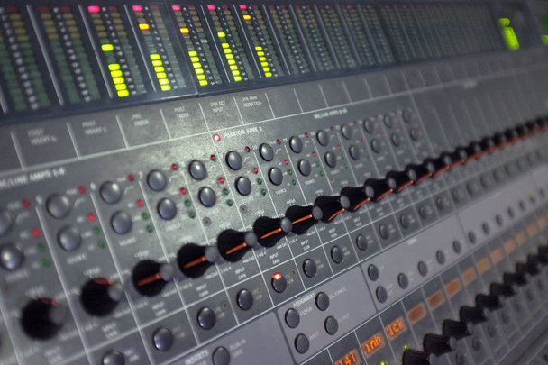 Mesa de masterização de som com muitos botões, controles deslizantes e leds
 - Foto, Imagem