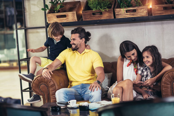 Famille avec deux enfants assis au café après les courses
 - Photo, image