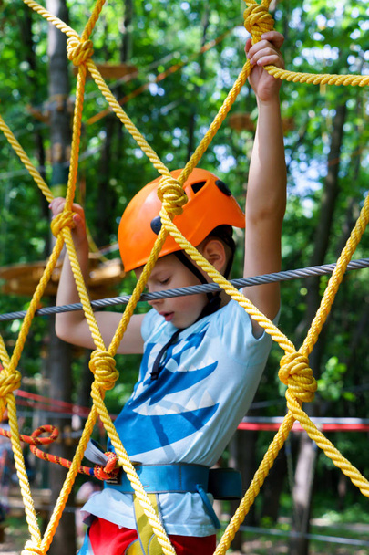Мальчик забирается на веревочный парк
 - Фото, изображение