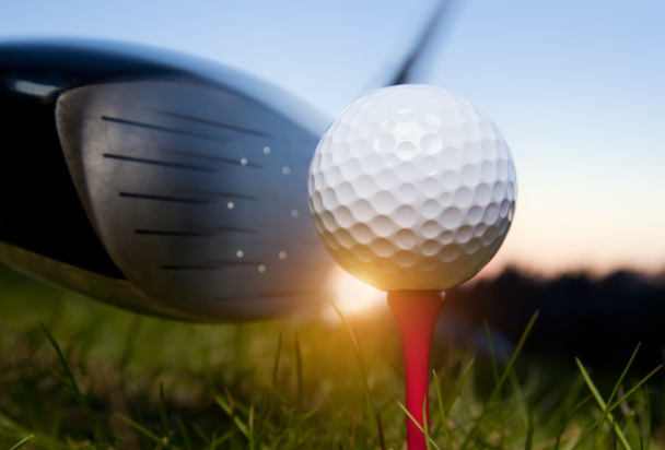 Golf club en de bal in het gras met zonlicht - Foto, afbeelding