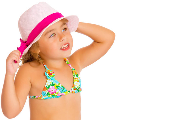 A small tanned girl in a swimsuit and a hat. - Foto, Imagen