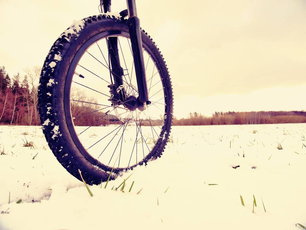 Bicicleta de montaña en polvo nieve. Camino perdido en la deriva de nieve. Detalle de rueda
 - Foto, imagen