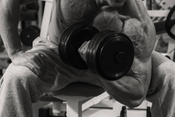 Μυώδης άνδρας bodybuilder προπόνηση στο γυμναστήριο και να ποζάρουν μυών - Φωτογραφία, εικόνα