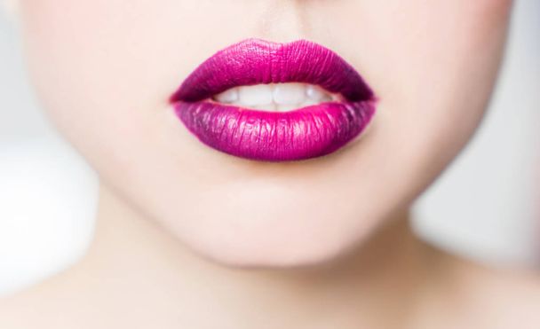 Labios femeninos brillantes lápiz labial rosa púrpura. El color de moda de la juventud con estilo en los labios, primer plano
. - Foto, Imagen