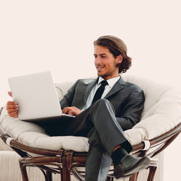 modern businessman with a laptop sitting in a stylish comfortable chair - Photo, Image