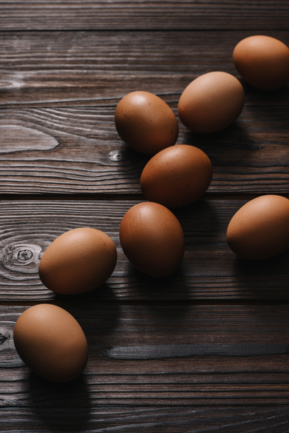raw chiken eggs on wooden table - Fotó, kép