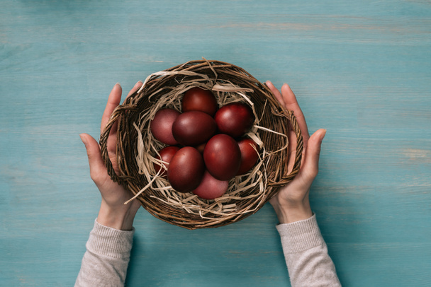 cropped image of woman holding easter basket with painted eggs - Foto, Imagen