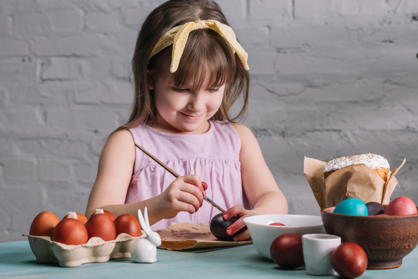 adorabile bambino pittura uova di Pasqua con pennello
 - Foto, immagini