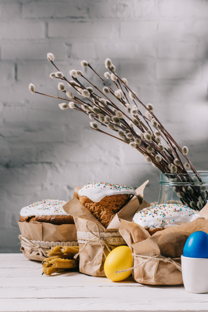 húsvéti kenyér, festett tojások csirke és a fából készült asztal gyertyák - Fotó, kép