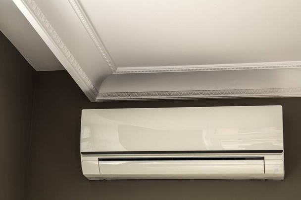 Kühle Klimaanlage an dunkler Wand im Innenraum - Foto, Bild