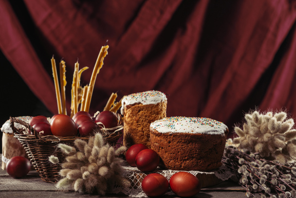 zblízka pohled jehnědy, svíčky, Velikonoční dorty a malované slepičí vejce na stole - Fotografie, Obrázek