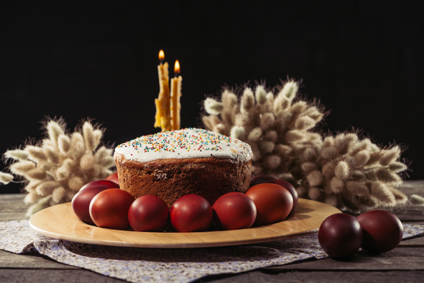 Malovaný slepičí vejce, Velikonoční dort a hořící svíčky na dřevěný stůl  - Fotografie, Obrázek