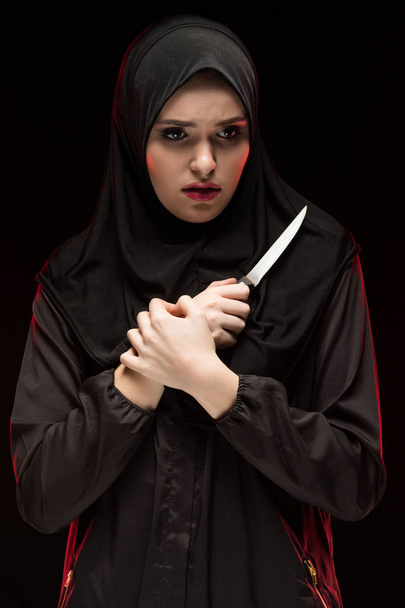 Portret van jonge moslimvrouw bedrijf mes in handen  - Foto, afbeelding