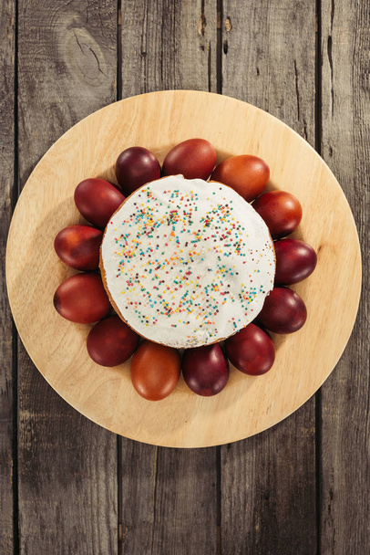 pohled shora sladké domácí Velikonoční koláč a malované slepičí vejce na dřevěný stůl - Fotografie, Obrázek