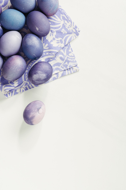 vista dall'alto di uova di Pasqua dipinte di viola con tovagliolo su grigio
 - Foto, immagini