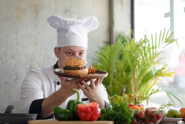 Chef in in a restaurant or hotel kitchen, checking up his food a - Foto, imagen
