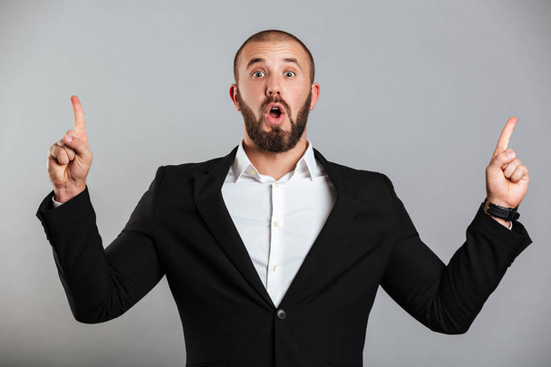 Image of surprised caucasian man in black business suit posing o - Foto, immagini
