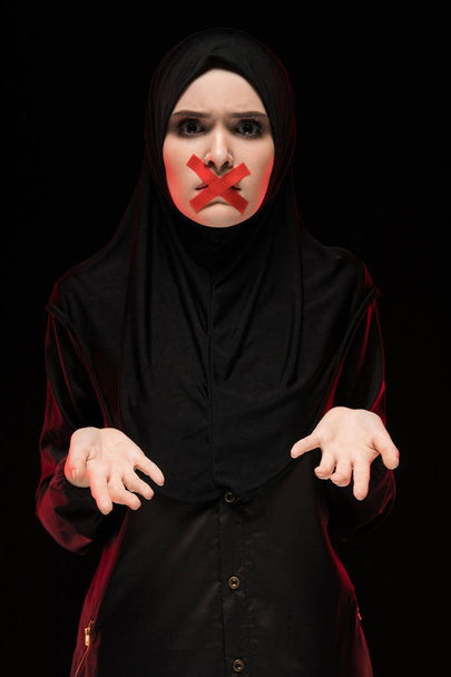 jeune femme musulmane avec croix rouge sur la bouche debout avec les paumes vers le haut
 - Photo, image