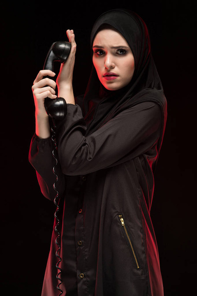 portrait of young Muslim woman holding handset of vintage phone - Fotoğraf, Görsel