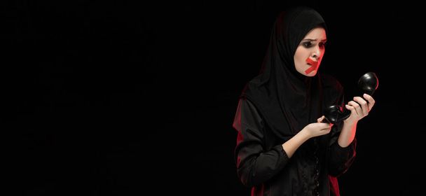 young scared Muslim woman with red cross on mouth trying call for help - Photo, Image