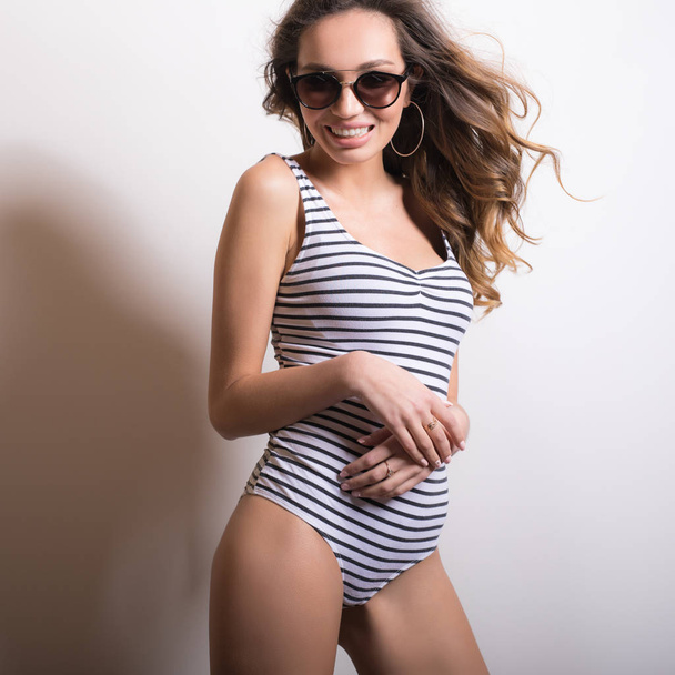 Young beautifull woman in striped swimsuit studio portrait. - Valokuva, kuva