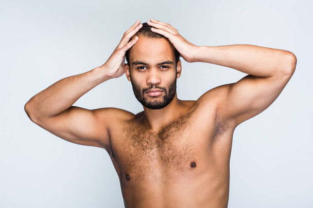 Charming and confidant. Portrait of handsome shirtless young black man looking at camera while standing against white background - Photo, image