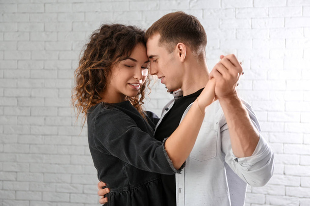 Young loving couple dancing in light room - Фото, изображение