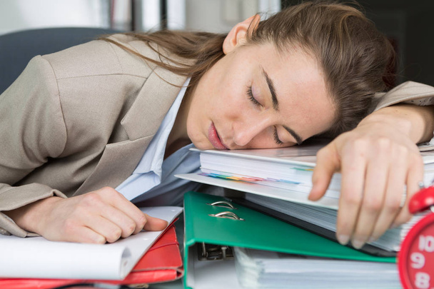 woman having a nap on top of the folders - Foto, imagen