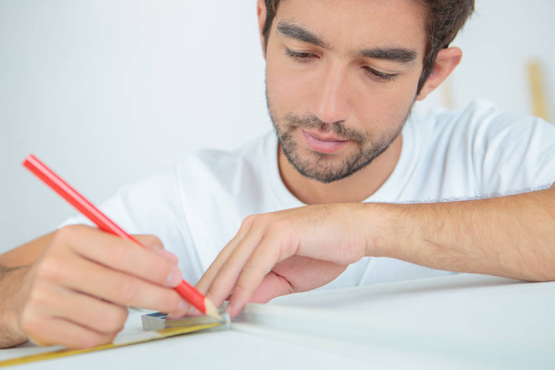 man marking an object using pencil - Фото, изображение