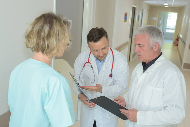 medical staffs conversation on the clipboard information - Фото, зображення