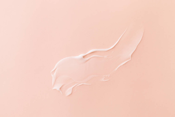 Smeared cream on pink pastel background - Foto, imagen