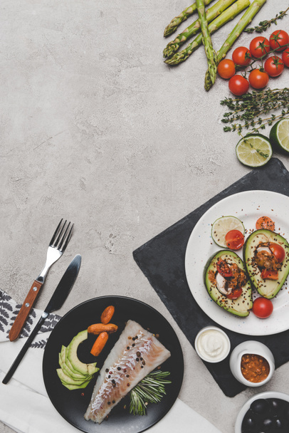 top view of delicious healthy dishes with fish and avocado on grey - Zdjęcie, obraz