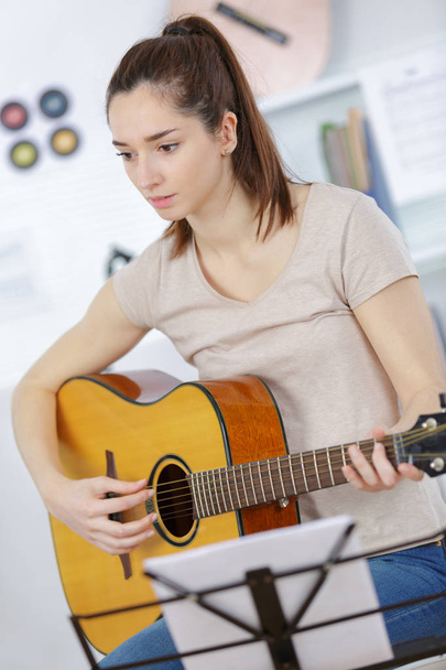 girl playing guitar in the living room - Fotoğraf, Görsel