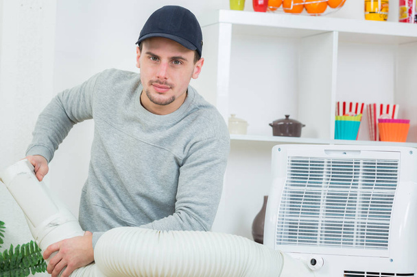 handsome technician installing air-conditioner in building - Фото, зображення