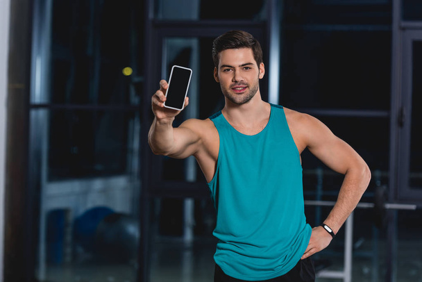 handsome sportsman showing smartphone with blank screen  - Fotoğraf, Görsel