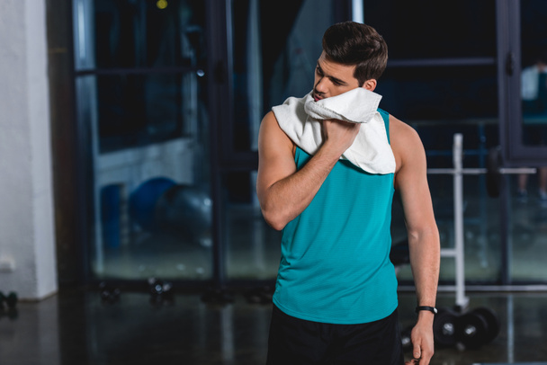 tired sweaty sportsman with towel after training in gym - Photo, Image